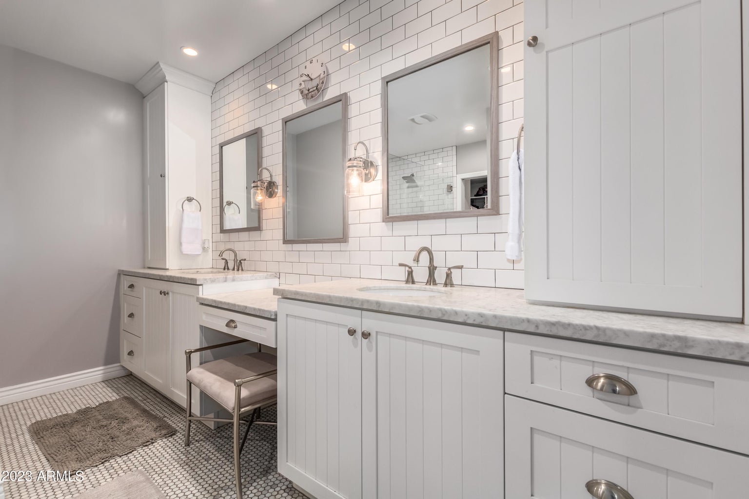 A luxury real estate bathroom in Greater Scottsdale with white cabinets and marble counter tops, designed by Denali Development Construction.