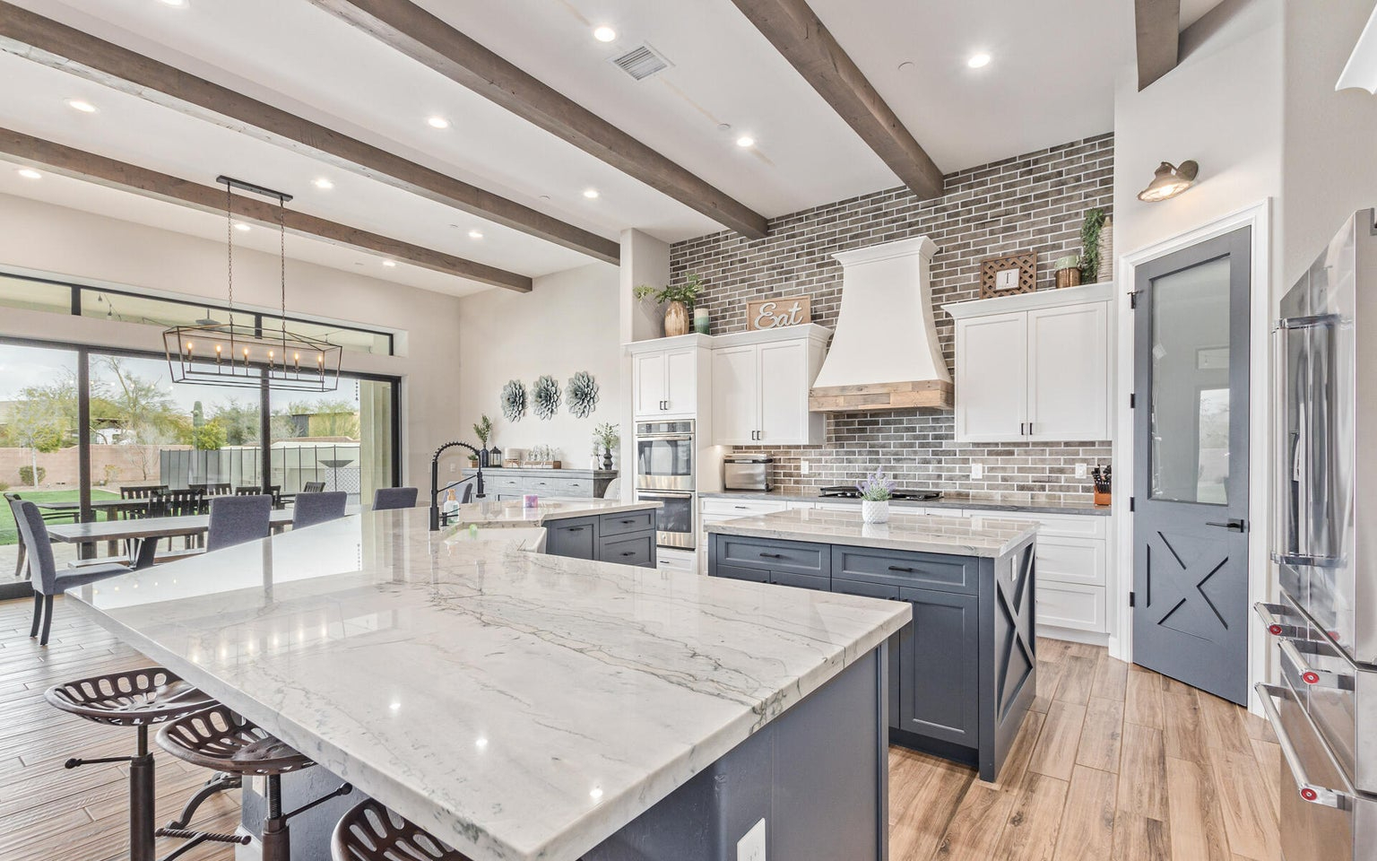 A kitchen with a large island and wood beams in a luxury real estate property developed by Denali Development Construction in Greater Scottsdale.