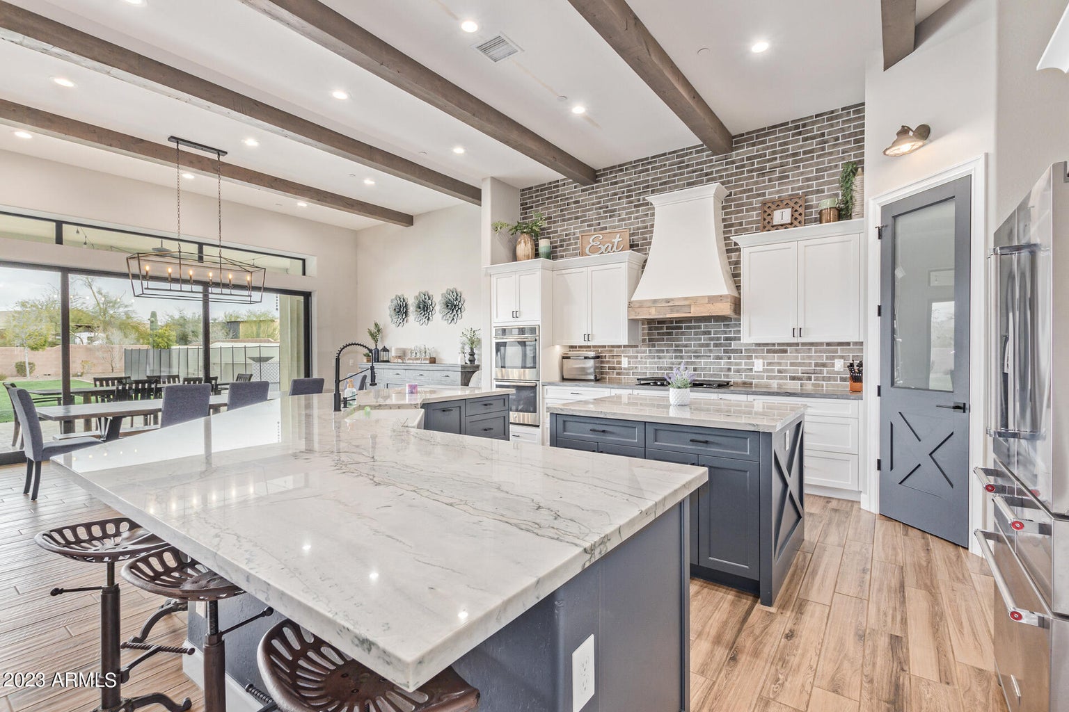 A kitchen with a large island and wood beams in a luxury real estate property developed by Denali Development Construction in Greater Scottsdale.