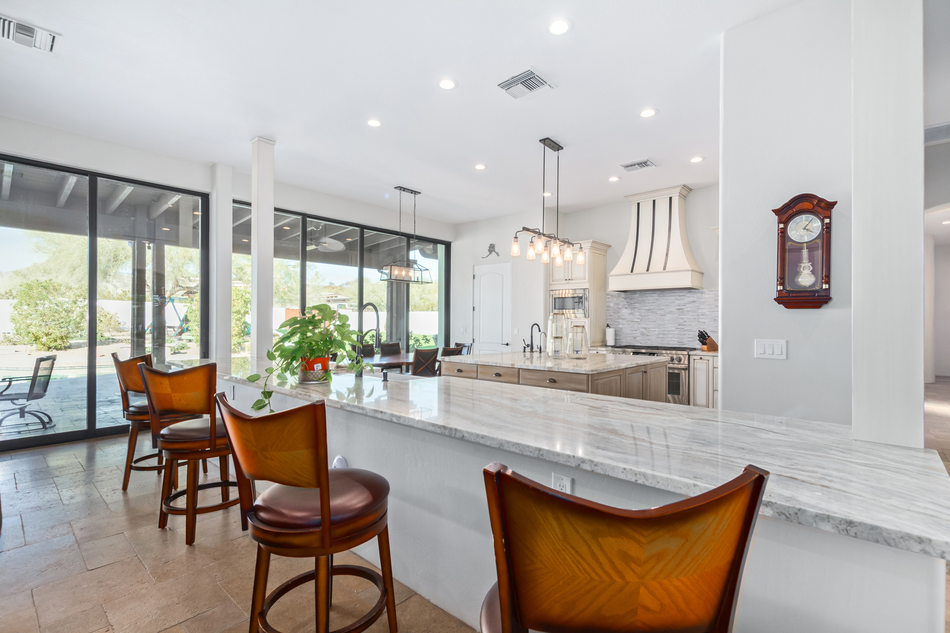 A luxurious kitchen with marble counter tops and bar stools in Greater Scottsdale's Denali Development Construction.